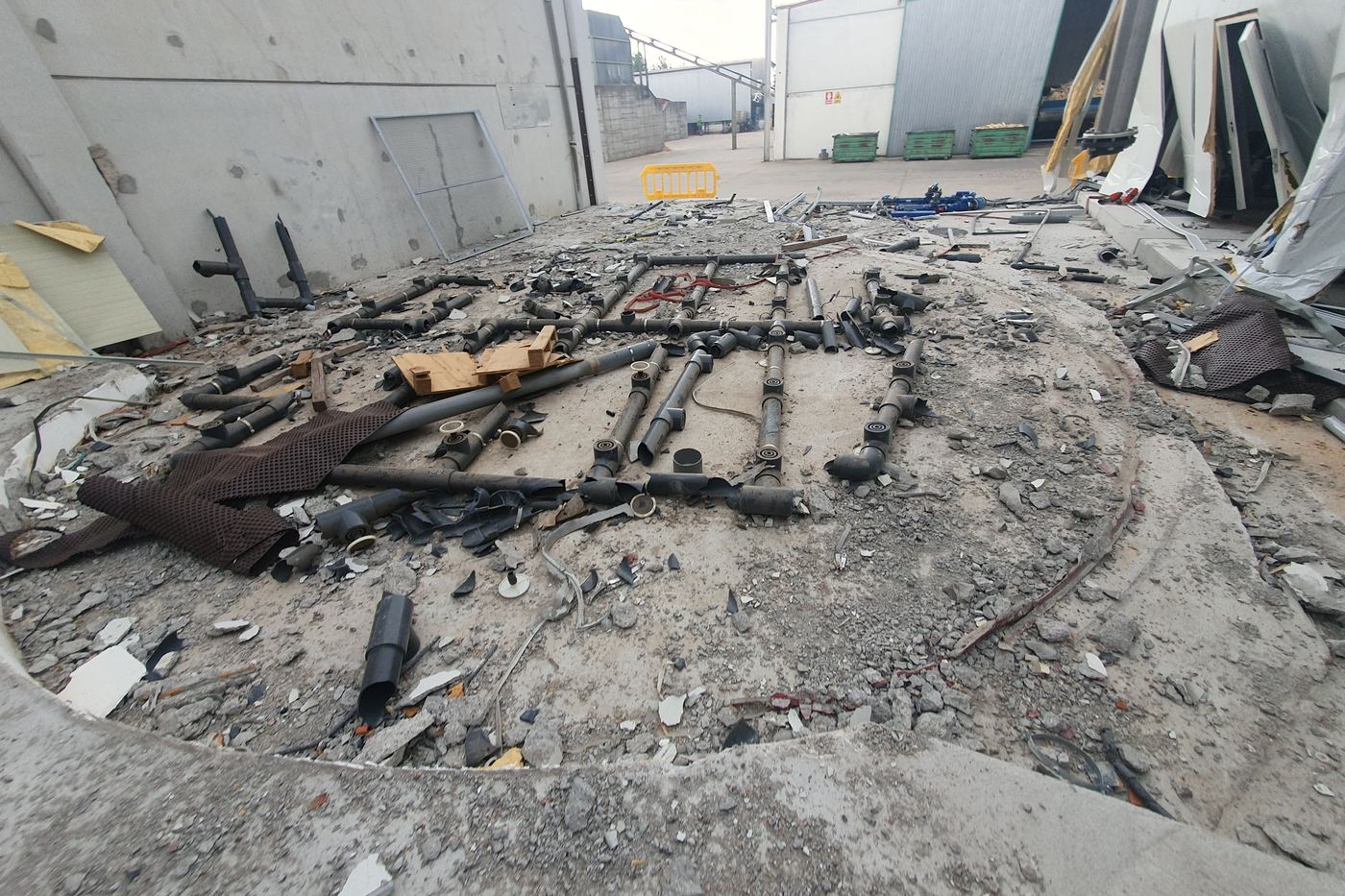 Restos de instalación tras una explosión en el exterior de una nave industrial